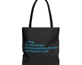 May include: Black tote bag with black handles. The bag features the text "Teaching: The only profession where you steal things from home and bring them to work" in blue. The bag is designed for carrying items.