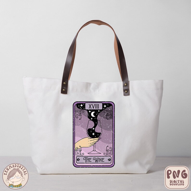 Pu&ograve; includere: Una borsa tote in tela bianca con manici in pelle marrone e un design di carta dei tarocchi viola. La carta raffigura un bicchiere di vino con una luna crescente e stelle al suo interno. La carta &egrave; etichettata "XVIII Il Vino".
