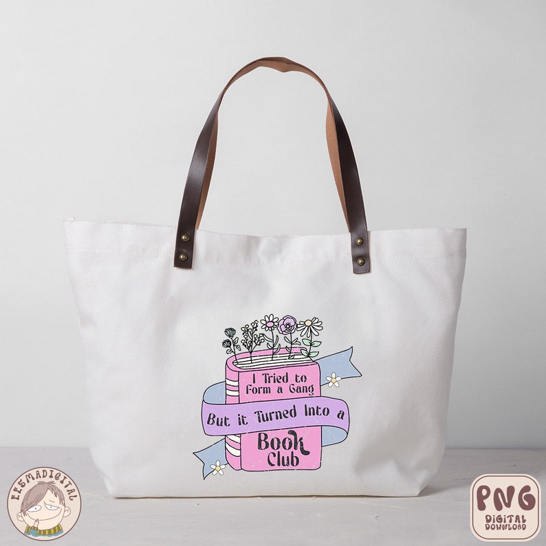 Puede incluir: Una bolsa de tela blanca con asas de cuero marr&oacute;n y un dise&ntilde;o rosa y azul con un libro con flores y el texto "Intent&eacute; formar una pandilla, pero se convirti&oacute; en un club de lectura".