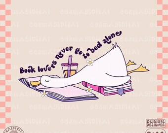 May include: A white duck with a pink beak and yellow feet is sleeping on a stack of books. The duck is holding a book in its wings. The text "Book lovers never go to bed alone" is written in purple and pink letters above the duck. A cup of boba tea is next to the duck.