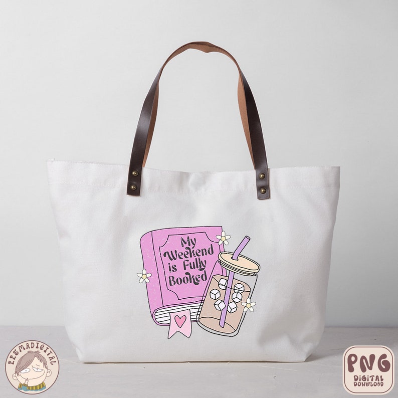 May include: A white tote bag with brown leather handles. The bag has a pink book with the text "My Weekend is Fully Booked" and a glass of iced coffee with a straw.