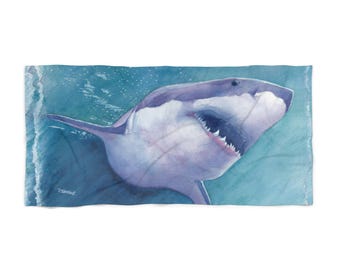 May include: A watercolor painting of a great white shark swimming in the ocean. The shark is depicted in shades of blue and purple, with its mouth open and teeth visible. The background is a light blue color, with hints of white waves.