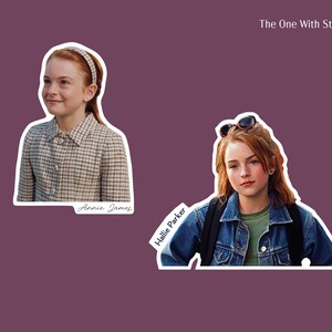 Two stickers of Hallie Parker and Annie James arriving at camp 1) Annie in gingham print dress and matching headband smiling and 2) Hallie in jean jacket and green t-shirt with sunglasses on her head