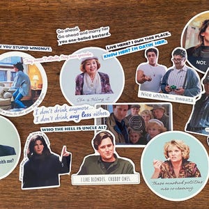 May include: A collection of 11 round stickers featuring scenes and quotes from the movie 'Love Actually'. The stickers feature various characters from the film, including the Prime Minister, Mark, and Juliet. The stickers are printed on white paper with a glossy finish.