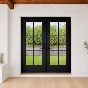 May include: Black double doors with a grid pattern, offering a view of a green lawn and trees. The doors are set in a white wall with a wooden beam above. A small potted plant sits to the right, and a wall sconce is on the left.