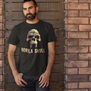 May include: A black t-shirt with a graphic of a yellow and brown gorilla skull. The text "GORILLA SKULL" is printed in red and white below the skull.