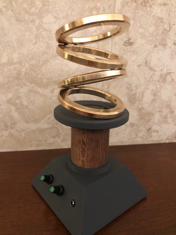 Handcrafted brass spinning rings that orbit and gyrate continuously — a mesmerizing desk or shelf sculpture that's equal parts physics demonstration and fine art object.