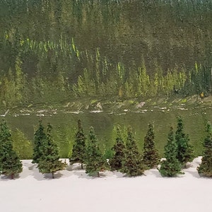 Puede incluir: Un conjunto de 18 árboles de hoja perenne en miniatura, de aproximadamente 2,5 cm de altura, dispuestos en fila sobre una superficie blanca. Los árboles están hechos de materiales verdes y marrones, que se asemejan a un bosque en miniatura.