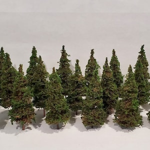 May include: A collection of 16 miniature evergreen trees, perfect for model railroading or miniature landscaping. The trees are made of green and brown materials and are approximately 3 inches tall.