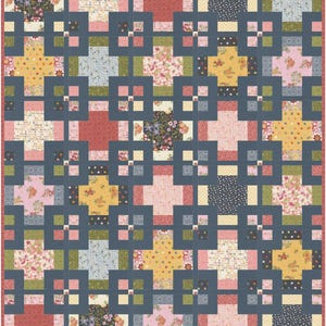 Puede incluir: Una colcha rectangular con un patrón de cuadrícula repetitivo de tiras de tela azul oscuro que enmarcan varios parches cuadrados. Los parches muestran diversos estampados florales, geométricos y de lunares en tonos rosa, amarillo, verde y azul marino.