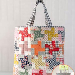 May include: A large, quilted tote bag with a patchwork design in various colors and patterns, including floral, gingham, and solid fabrics. The handles are a black and white checkered pattern. The text "Quilter's Big Tote" is at the top.