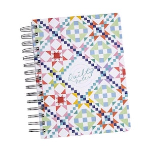 Peut inclure: Un carnet à spirales avec une couverture à motifs de patchwork colorés. Le motif présente des formes géométriques rouges, bleues, vertes et jaunes. Le texte "Quilty Notes" est dans un cercle sur la couverture.