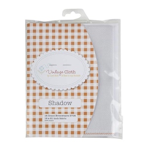 May include: A pack of white 14 count evenweave Aida fabric for cross stitch. The fabric is 19 by 21 inches and is 100% cotton. The pack has a brown and white gingham pattern and says "Vintage Cloth by Lart Holt of Bee in my Bonnet" and "Shadow".