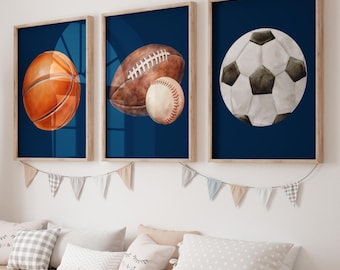 May include: Three framed prints with a blue background and a white border. Each print features a different sports ball: a basketball, a football, and a soccer ball.