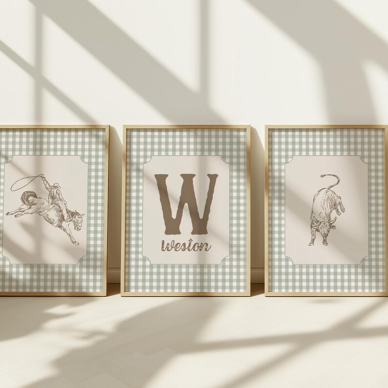 May include: Three framed prints with a Western theme. The prints feature a cowboy on a bucking bronco, a large letter "W" with the name "Weston" below, and a bull. The frames have a gold finish and a light green and white checkered border.