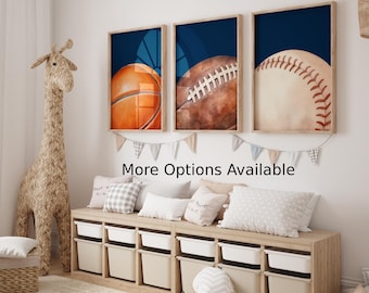 Peut inclure: Trois impressions encadrées de ballons de sport sur fond bleu. Les impressions représentent un ballon de basket, un ballon de football américain et un ballon de baseball. Les impressions sont accrochées à un mur blanc au-dessus d'une étagère en bois avec des bacs de rangement.