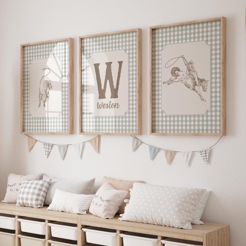 May include: Three framed prints with a Western theme. One print features a bucking bronco, another a letter "W" with the name "Weston", and the third a drawing of a bull. The frames are light wood, and the background is a gingham pattern.