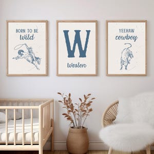 K&ouml;nnte beinhalten: Drei gerahmte Drucke mit Western-Motiv. Der erste Druck zeigt einen Cowboy, der ein wildes Pferd reitet, mit dem Text "Born to be wild". Der zweite Druck zeigt den Buchstaben "W" mit dem Namen "Weston" darunter. Der dritte Druck zeigt einen Stier mit dem Text "Yeehaw cowboy".