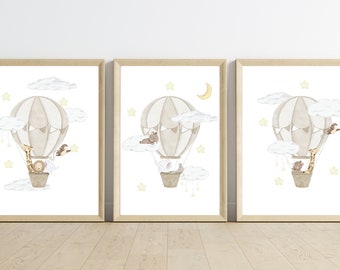 May include: Three framed prints with a watercolor illustration of a hot air balloon with animals. The balloon is beige with brown accents and is filled with a giraffe, a bear, and a rabbit. The balloon is floating in the sky with clouds and stars. The prints are perfect for a nursery or child's room.