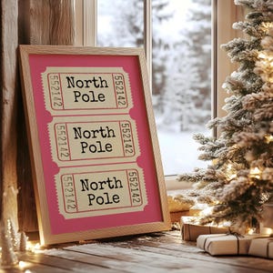 May include: A framed print with a pink background and three tickets with the text "North Pole" and the number "552142" on each ticket.