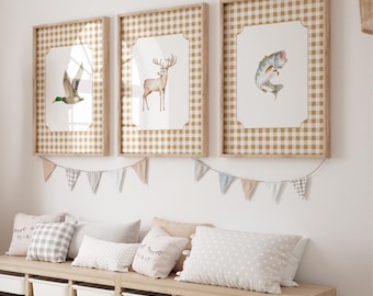 Può includere: Tre stampe incorniciate con un bordo a motivo gingham. Le stampe presentano un'illustrazione ad acquerello di un'anatra, un cervo e un pesce. Le stampe sono appese a una parete bianca sopra una panca di legno con cuscini.