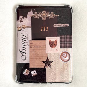May include: Clear protective phone case with a collage design. The design includes a cowhide pattern, a decorative flourish, the number "111", the words "forever & always", a cat postage stamp, and the word "Amour".