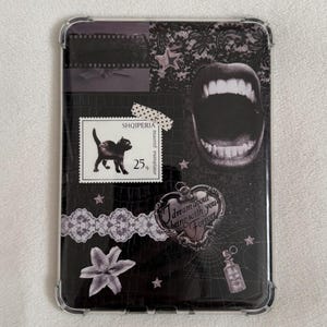 May include: A black and white phone case with a collage design. The design includes a postage stamp with a black cat, a heart pendant with the text "I dream about being with you forever", and an open mouth graphic.