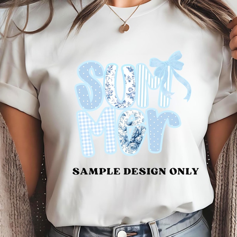 May include: White t-shirt with the word "SUMMER" in light blue, floral, and polka dot patterns. A light blue bow is above the letter "M". The text "SAMPLE DESIGN ONLY" is printed in black below the word "SUMMER".