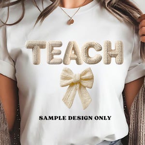 May include: White t-shirt with the word "TEACH" in a textured, off-white font, and a matching bow graphic. The text "SAMPLE DESIGN ONLY" is printed below the bow in black.