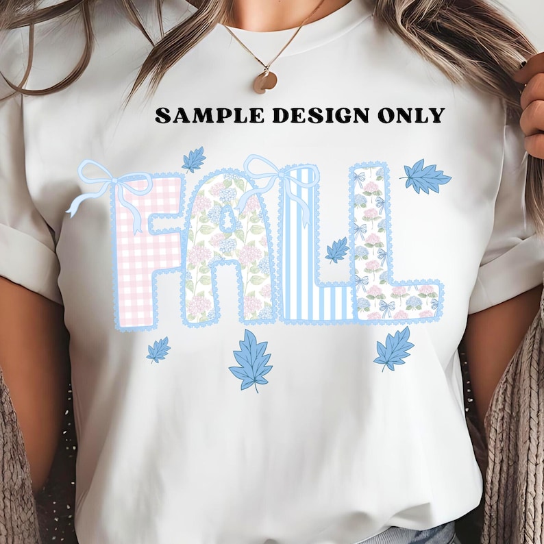 K&ouml;nnte beinhalten: Wei&szlig;es T-Shirt mit dem Wort "FALL" in einem Patchwork-Design. Die Buchstaben sind in rosa Vichy, floralen und blau gestreiften Mustern gehalten, mit blauen Blattakzenten. Der Text "SAMPLE DESIGN ONLY" steht &uuml;ber dem Wort "FALL".