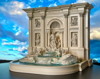May include: A white miniature replica of the Trevi Fountain in Rome, Italy. The fountain features a sculpted archway with the inscription "BENEDICTUS XIV PONT-MAX", and a central figure of Oceanus riding a chariot drawn by seahorses. The fountain is surrounded by a pool of water.