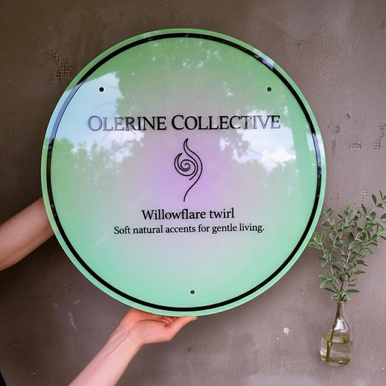 May include: A circular light green sign with a black border and black text that reads Olerine Collective, Willowflare twirl, and Soft natural accents for gentle living. A black spiral icon is centered between the brand name and text.