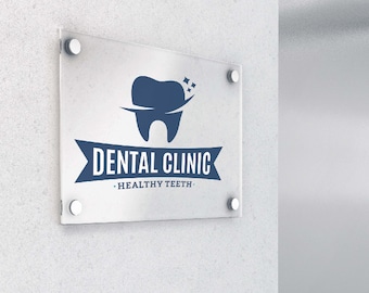 May include: A rectangular clear acrylic sign mounted with four silver standoffs. The sign features a dark blue logo of a tooth with two small stars above it, followed by the text DENTAL CLINIC and the phrase HEALTHY TEETH.