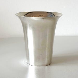 May include: A silver vase with a flared top and a smooth, polished finish.