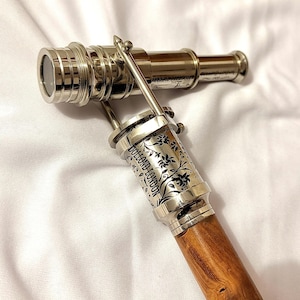 以下が含まれることがあります： 木製のハンドルが付いた、磨かれた真鍮製の望遠鏡。望遠鏡は、ハンドルに「DOLLOND LONDON」の文字と花の模様が刻まれた銀色のボディをしています。望遠鏡の長さは約25cmです。