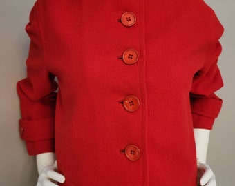 May include: A red wool jacket with a stand-up collar and five large red buttons down the front.