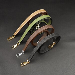 May include: Four leather straps with gold-toned clasps. The straps are in different colors: brown, green, tan, and black.