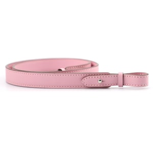 May include: A pink leather camera strap with a single silver rivet and a small loop at the end.