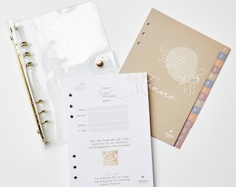 Könnte beinhalten: Ein durchsichtiger Kunststoffordner mit goldfarbenen Ringen und einem Druckknopfverschluss, neben einem beigen Monatsplaner und einer weißen Karte. Die Karte enthält deutschen Text, darunter "Budget PLANER" und einen QR-Code. Der Planer hat einen "Januar"-Abschnitt.