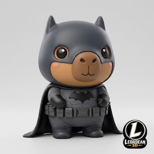 Puede incluir: Una figura estilizada de un oso marrón que lleva una capucha, capa y traje táctico de color gris oscuro inspirados en Batman, con un cinturón de herramientas. El personaje tiene grandes ojos negros, una nariz pequeña y mejillas rosadas. Logo LEORDEAN 3D.