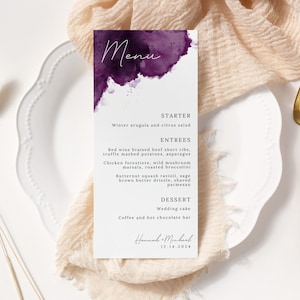 May include: A wedding menu card with a purple watercolor design. The menu includes starter, entrees, and dessert options. The card is signed "Hannah & Michael" and the date "12.14.2024".