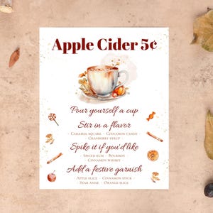 May include: A watercolor illustration of a white mug filled with apple cider. The text reads "Apple Cider 5&cent;" and includes instructions for customizing the drink with flavors and garnishes.