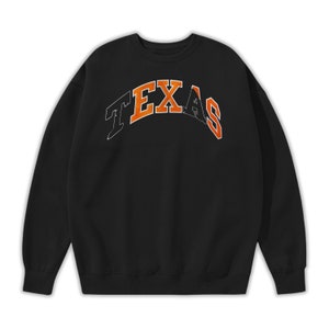 May include: Black sweatshirt with an orange and white arched "TEXAS" graphic.