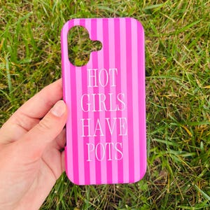 May include: A rectangular phone case featuring a vertical striped pattern in alternating shades of bright pink and magenta. The text HOT GIRLS HAVE POTS is printed in white capital letters in the centre. A camera cutout is located at the top left.