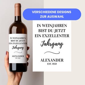 Könnte beinhalten: Eine braune Weinflasche mit einem weißen Etikett mit schwarzem Text, der lautet: "IN WEINJAHREN BIST DU JETZT EIN EXZELLENTER Jahrgang ALEXANDER EST. 1959." Ein zweites Design wird mit demselben Text gezeigt. Das Bild enthält auch den Text "VERSCHIEDENE DESIGNS ZUR AUSWAHL."