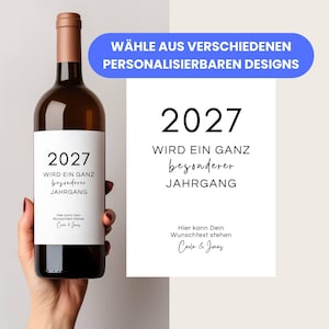 May include: A brown wine bottle with a white label featuring the year "2027" and the text "Wird ein ganz besonderer Jahrgang". A blue banner reads "WÄHLE AUS VERSCHIEDENEN PERSONALISIERBAREN DESIGNS". A white card displays the same text.