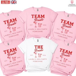 May include: A selection of pink and white t-shirts featuring the text "TEAM Bride" and "THE Bride" in red. Each shirt includes the text "LAURA'S HEN PARTY YORKSHIRE" and the year "2026".