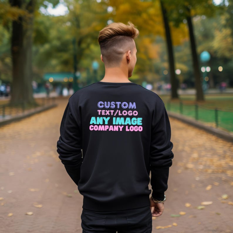 May include: A black long-sleeve sweatshirt featuring the text CUSTOM TEXT/LOGO, ANY IMAGE, and COMPANY LOGO printed on the back in purple, light blue, and pink lettering. The garment has a crew neckline and ribbed cuffs and hem.