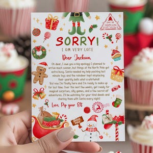 May include: A Christmas card with the text "SORRY! I AM VERY LATE Dear Jackson", held by a person. The card is decorated with festive illustrations of an elf, gifts, and a snowman. Cupcakes with red and white striped wrappers are in the background.