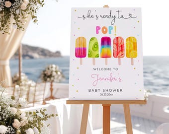 May include: A white sign with a colourful popsicle design and the text "She's ready to POP! Welcome to Jennifer's Baby Shower 05.25.20XX".